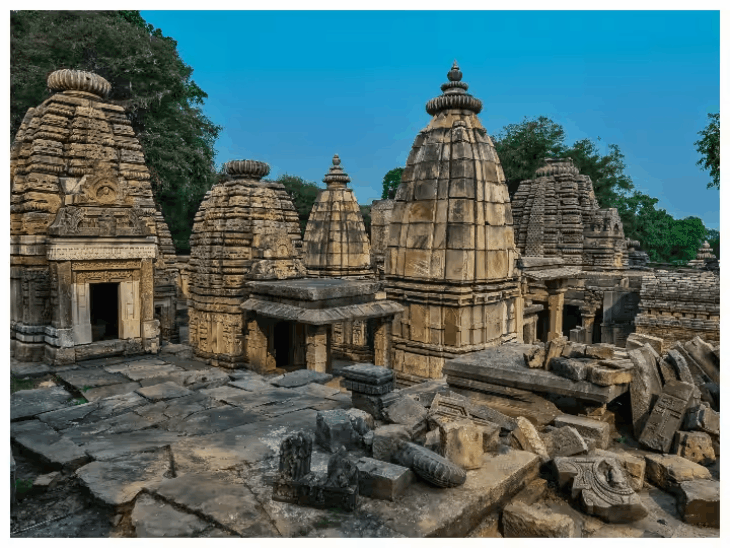 Ancient Indian temple architecture featuring an intricately carved stone tower under a clear blue sky
